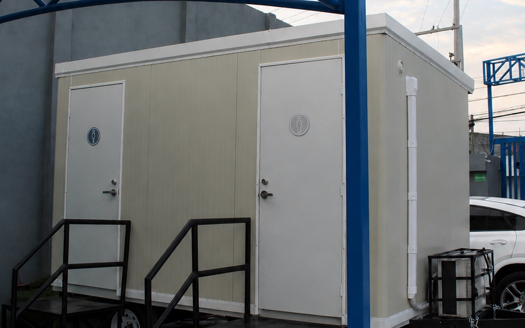 Detalle del módulo sanitario SANPORT en la planta industrial de Guadalupe, con accesos independientes para mujeres y hombres